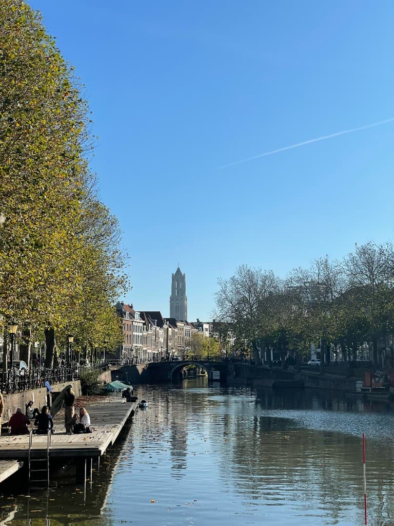 Sunny canal in Utrecht with the Dom tower in the distance